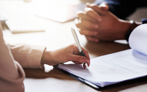 istock Business people, hands and signing contract, form or application for hire, recruitment or policy on table. Hand of person writing or filling in paperwork with pen for deal, agreement or information 1492234442