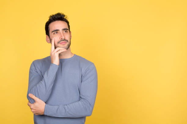 Thoughtful young man with a serene expression, gazing at copy space
