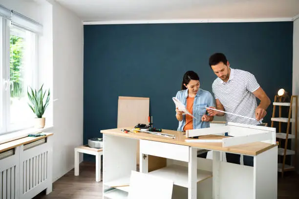 Couple assembling furniture in their new apartment.