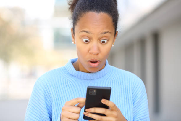 istock Surprised black woman using cell phone 1492239243