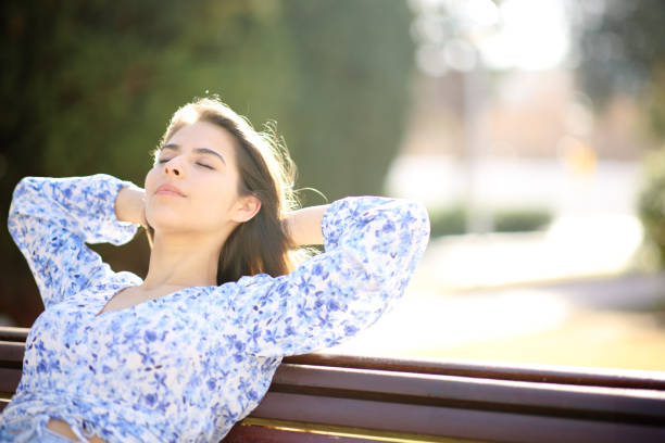 istock Woman relaxing and resting in a bench in a park 1492239909