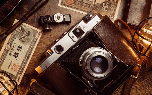 An old medium format camera with bellows lens from the 1940-50s along with vintage Japanese paper money and other items.