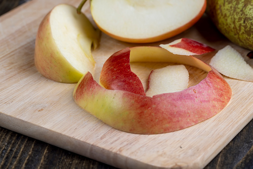 Peel and slice ripe red apples, delicious apples and their peel while cooking