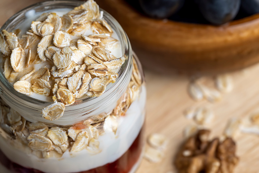 Fresh delicious yogurt made from milk with walnuts and muesli, dairy products with nuts and cereals