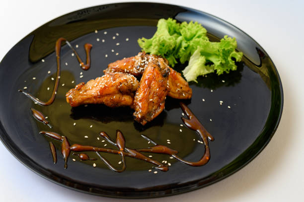 istock Caramelized chicken wings on a plate with salad and barbecue sauce 1492248672