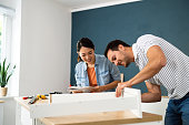 Couple assembling furniture together at their new apartment