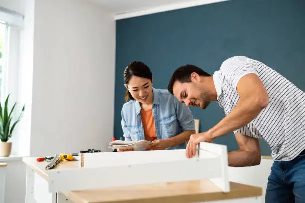 Couple assembling furniture in their new apartment.