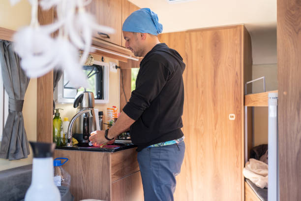 istock Man Washing Dishes İn The Kitchen Of His Caravan 1492250607