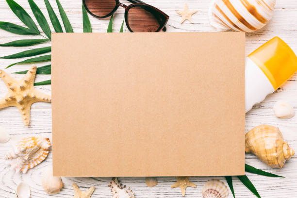 istock Summer time concept with blank greeting card and blank craft paper on colored background. Seashells from ocean shore in the shape of frame separated with space for text top view 1492256225