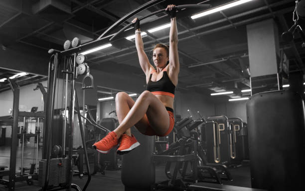 istock Female athlete with fit body hanging on the pullup bar while working her abs 1492257712