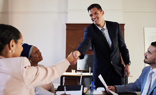 Businessman And Businesswoman Shaking Hands In Office