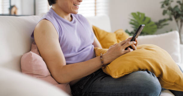 istock Gen Z queer man non-binary sitting easy relax happy read news on web page app at home sofa. Asia people LGBT young adult guy play web3, store shop e-commerce buyer, virtual retail network cyber paying 1492262698