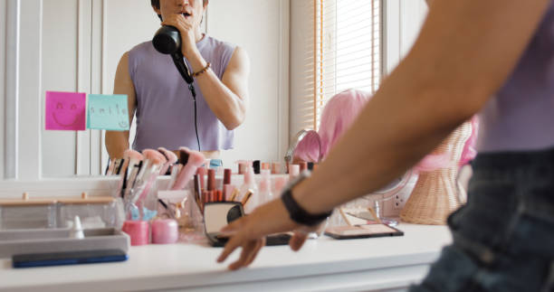 istock Self-love self-worth as young Gen Z LGBT queer non-binary men singing on hair dryer fun joy dance in front of mirror at home. Asia people adult guy happy relax enjoy pride month LGBTQIA youth culture. 1492263530