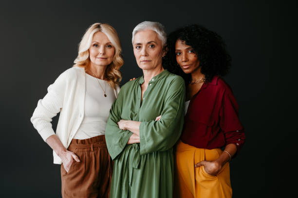 istock Three confident mature women looking at camera while bonding against grey background 1492268891