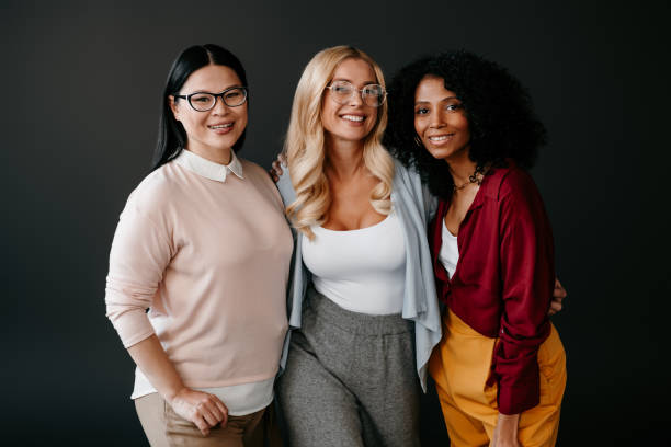 istock Three happy mature women bonding and smiling against grey background 1492268946