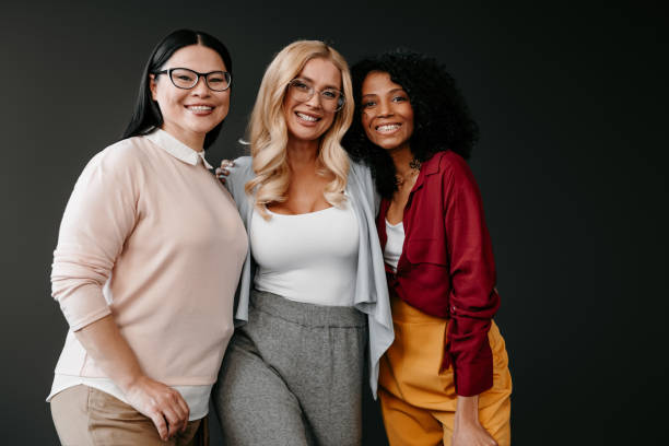 istock Three happy mature women bonding and smiling against grey background 1492268983