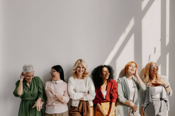 istock Multi-ethnic group of relaxed mature women bonding and smiling while leaning on the wall 1492268996