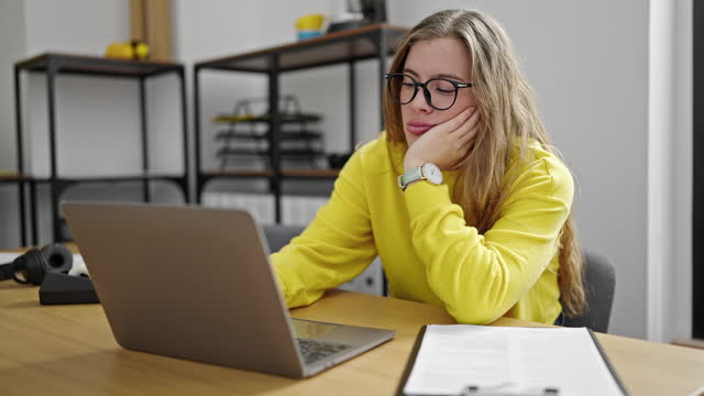 Young blonde woman business worker working with tired face at office