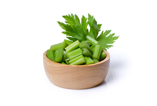 Fresh celery leaf in wooden bowl isolated on white background.