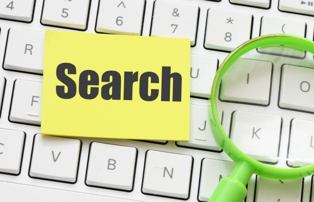 istock The word SEARCH in an office notebook next to a green magnifying glass. 1492275988