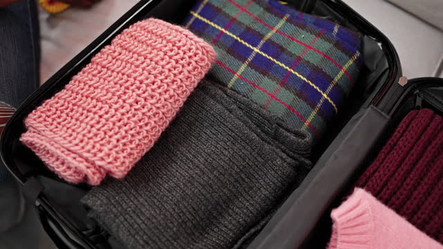 African american woman packing suitcase for trip at home