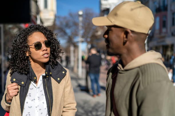Afro couple walking on city streets and talking.