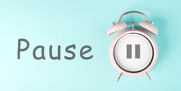 Alarm clock with pause sign, pastel color, time for a break, having lunch or a cup of coffee