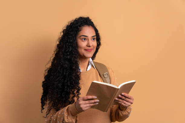 istock woman reading book to study in studio shot. 1492289176