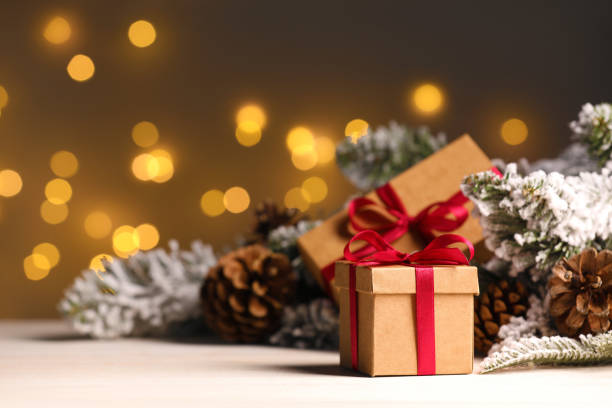 istock Gift boxes and Christmas decor on wooden table against blurred festive lights, space for text 1492291361