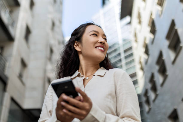 istock Smiling Asian businesswoman text messaging 1492292989