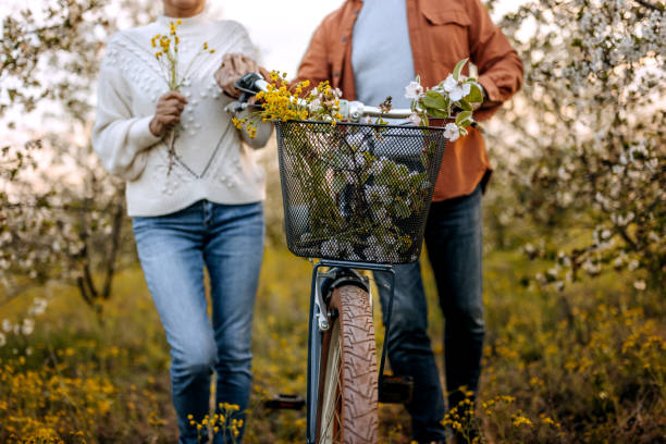 Active senior couple with bicycles walking through nature together