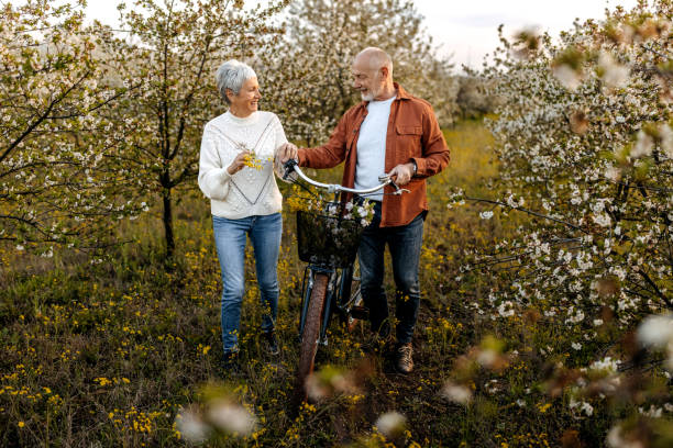istock Active senior couple with bicycles walking through nature together 1492294111
