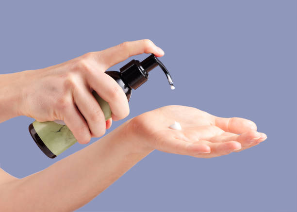 istock Moisturizer, skincare and hands with a bottle for cream isolated on a blue background in studio. Beauty, cosmetic and woman with lotion or sunscreen in palm for moisture, treatment and grooming 1492297406