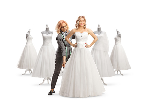 Fashion designer taking measures for a bridal dress isolated on white background isolated on white background