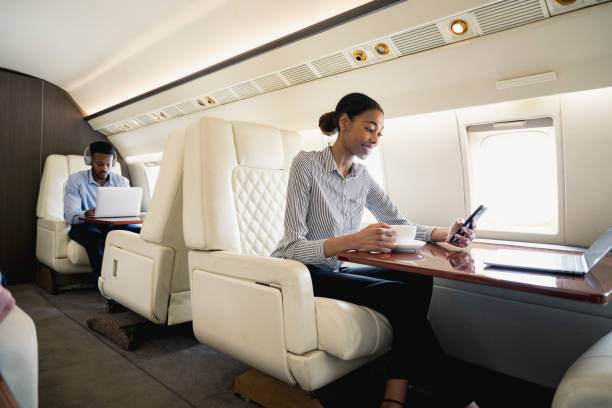 Smiling young Black executive flying on private jet