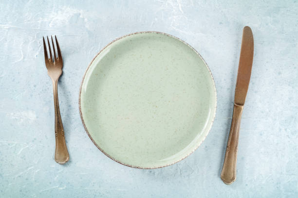 istock An empty green plate, with a fork and a knife, overhead flat lay 1492302294