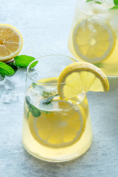 istock Lemonade with mint. Lemon water drink with ice. A glass and a pitcher 1492302404