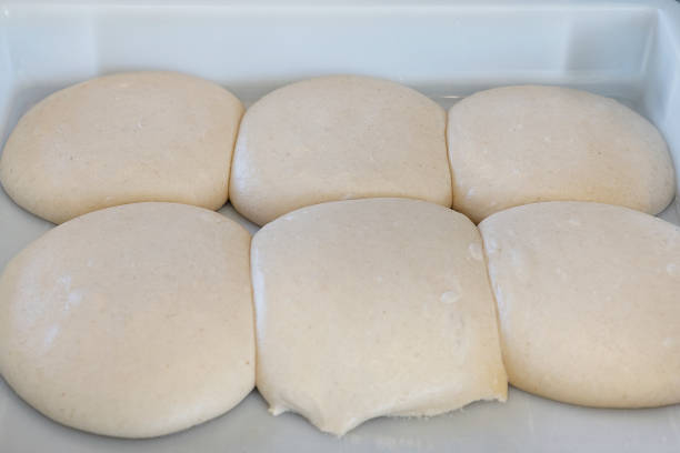 Fermenting dough divided in piles and set in a tray to rest, artisan bread making using traditional methods for a flavorsome result such as sourdough bread, baguettes, ciabattas, focaccias and more.
