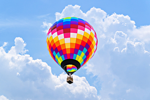 Colorful hot air balloon flying above the clouds