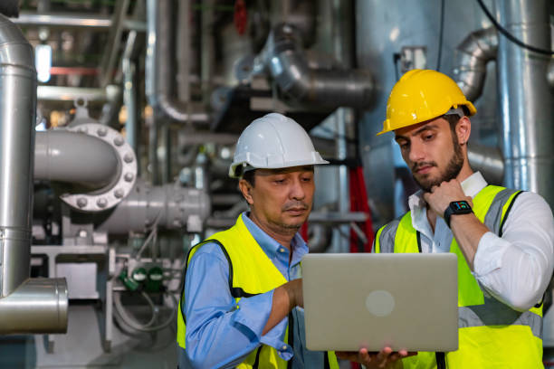 istock Two male engineer working together at factory site control room. 1492305402