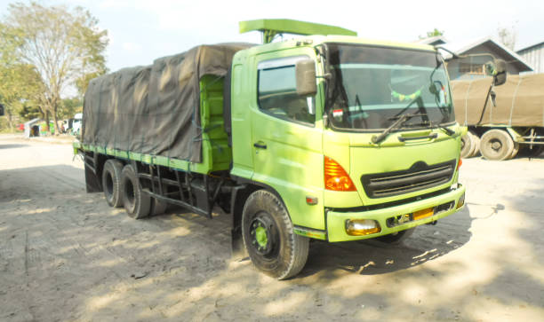 green colored flatbed heavy trucks used to transport and distribute cements sacks from factory to points of sales or distributors networks shops - axel imagens e fotografias de stock