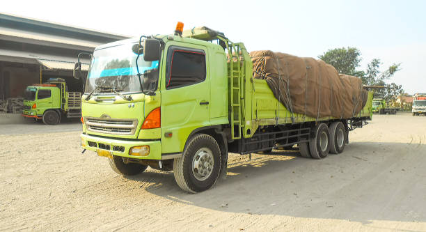 green colored flatbed heavy trucks used to transport and distribute cements sacks from factory to points of sales or distributors networks shops - axel imagens e fotografias de stock