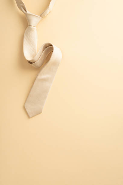 istock Minimalistic Father's Day design concept. Elevate Dad's day with a sophisticated Father's Day display. Top vertical view photo of beige silk tie on beige background with an empty space for text or ad 1492309713