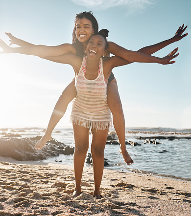 Friends, laughing or piggyback airplane by beach, ocean or sea in social gathering, vacation comedy or summer holiday. Smile, happy or black woman carrying girl in travel fun, bonding or comic games