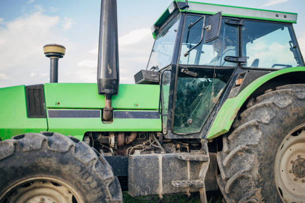 Senior farmer driving a tractor on agricultural field