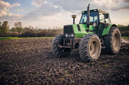 Senior farmer driving a tractor on agricultural field