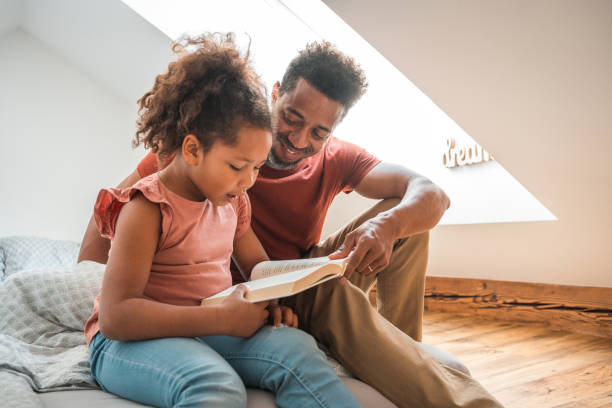 istock Mixed Race Girl Reading A Book With Her Father 1492313112