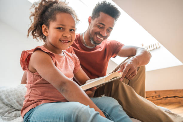 istock Mixed Race Girl Reading A Book With Her Father 1492313131