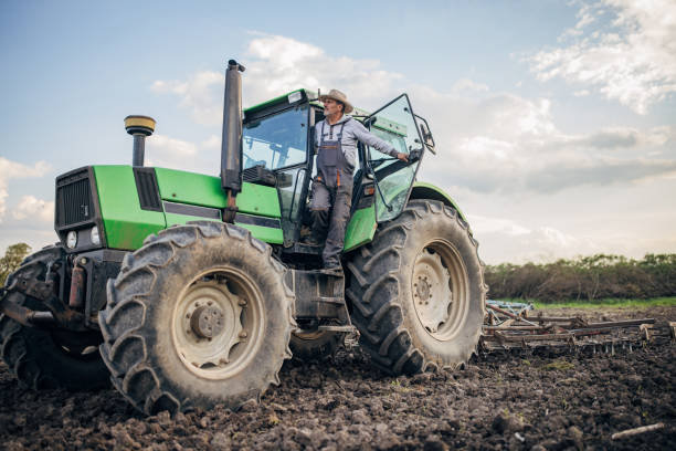 Senior farmer driving a tractor on agricultural field