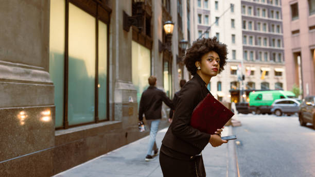 istock Efficient and Focused: Busy Black Professional Awaits Taxi, Managing Documents and Email 1492315167